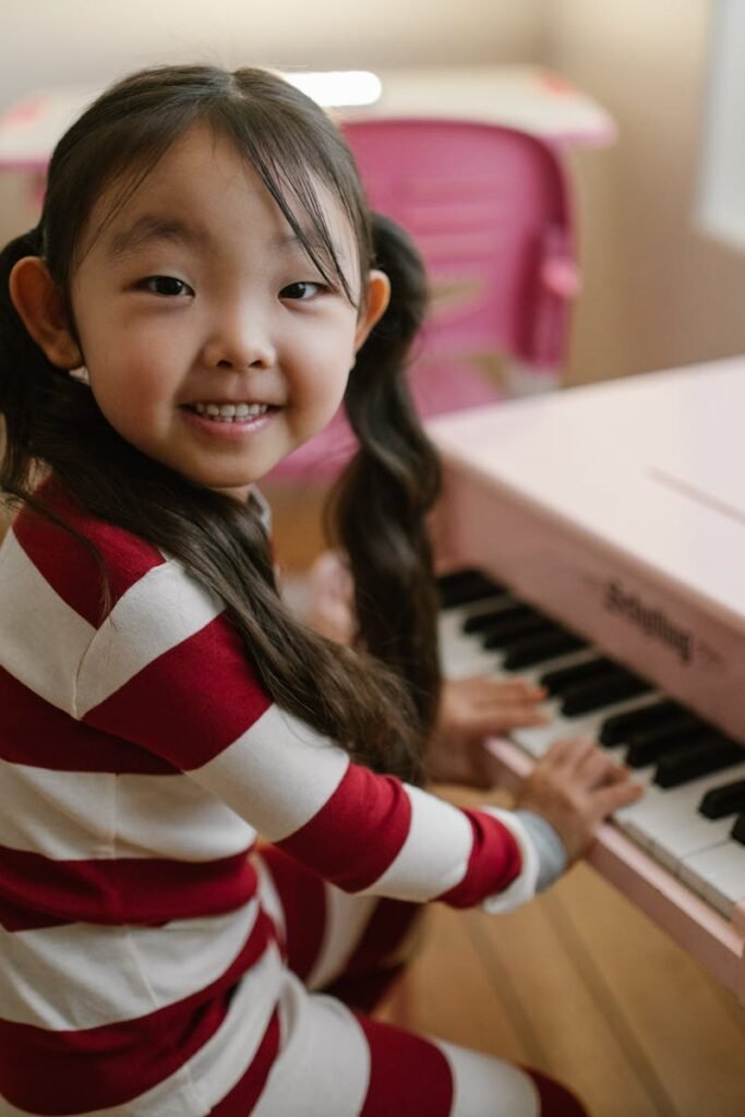 pexels-photo-10565565-10565565-1 Little girl smiling at the camera while she practices what she learned at piano lessons