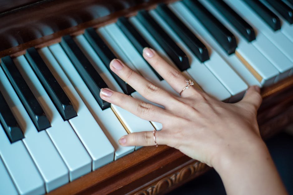 Close-up of a woman's hand playing piano keys during a music practice session using interleaved practice techniques